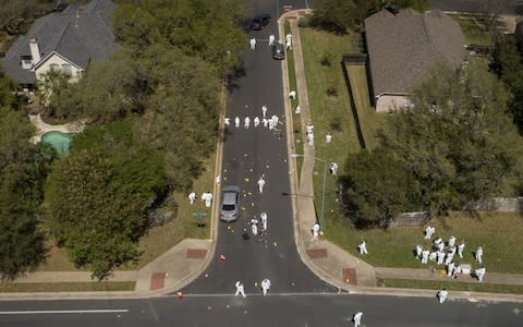 Investigators work at the scene of a bombing on Dawn Song Drive in the Travis Country neighborhood on Monday March 19