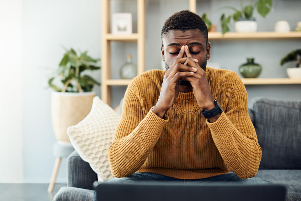 a man with his hands to his face inside a home