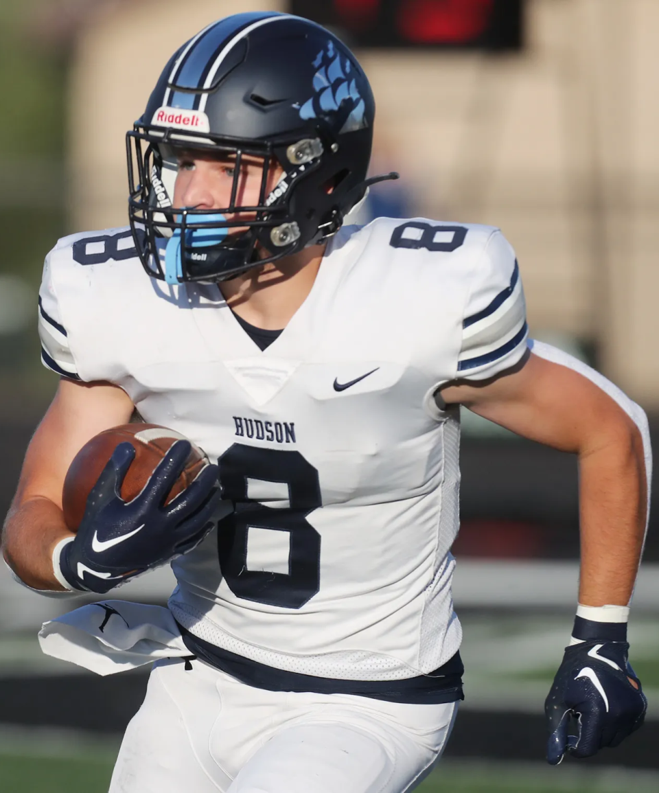 Hudson's Ian Ludewig returns a first-quarter kickoff for a touchdown at Highland High School, Friday, Aug. 18, 2023.