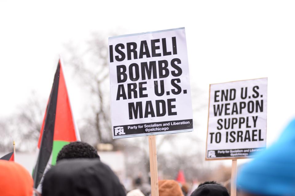 Pro-Palestinian protesters hold signs that say "Israeli bombs are US made" and "End US weapons supply to Israel."