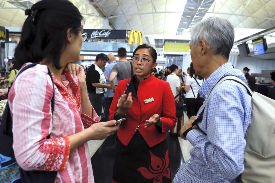 An airport employee explains the situation to travelers at the Airport in Hong Kong, Tuesday, Aug. 13, 2019. (Photo: Kin Cheung/AP)