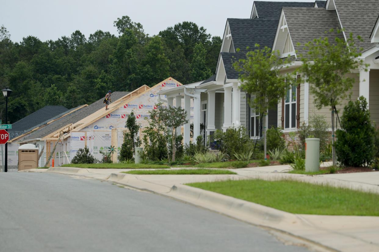 A crew member constructs the roof of a house that will complete a line of homes in the Canopy at Welaunee development Thursday, June 13, 2019. 