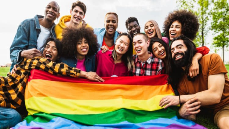 Group of people around Pride flag