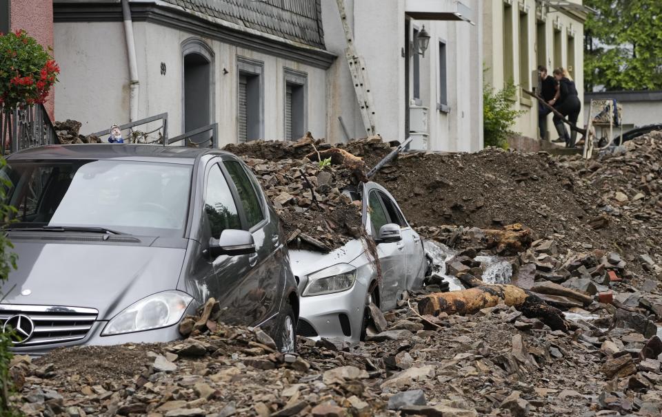 Cars in Hagen, Germany, on Thursday are covered by debris from the flooding of the River Volme.