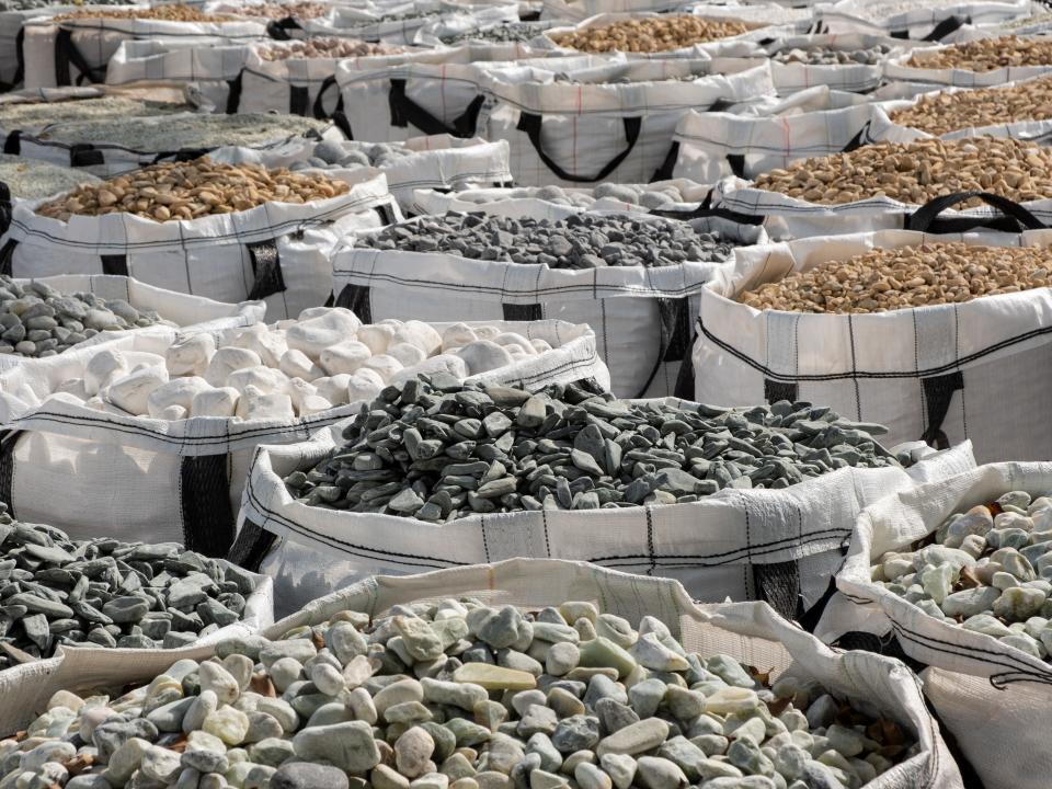 A warehouse filled with bags of different colored stones
