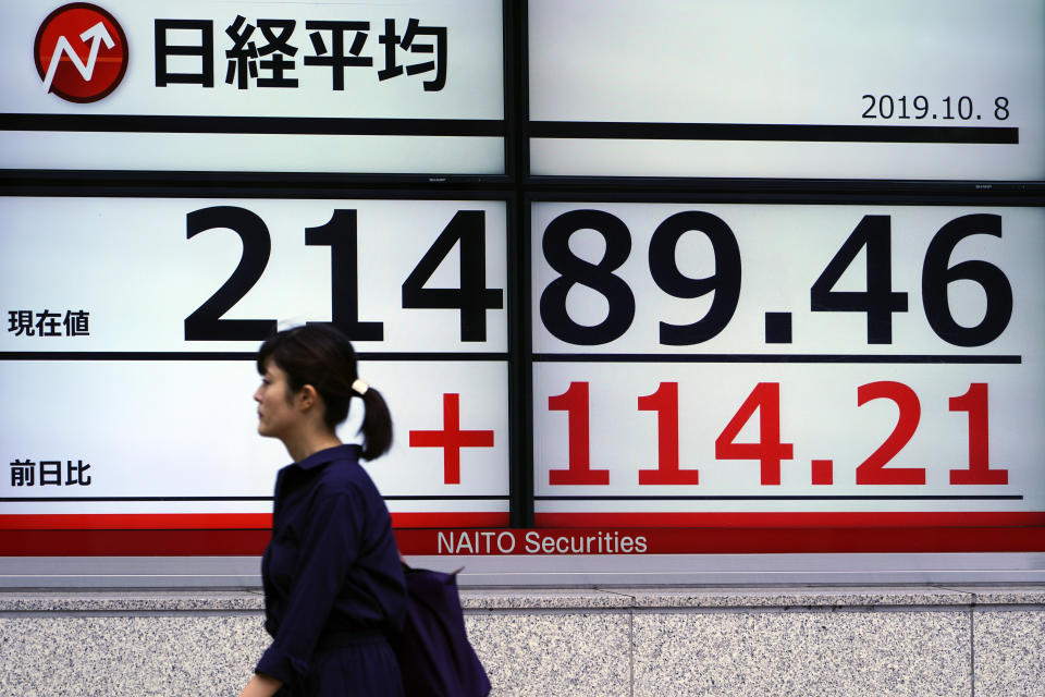 A woman walks past an electronic stock board showing Japan's Nikkei 225 index at a securities firm in Tokyo Tuesday, Oct. 8, 2019. (AP Photo/Eugene Hoshiko)