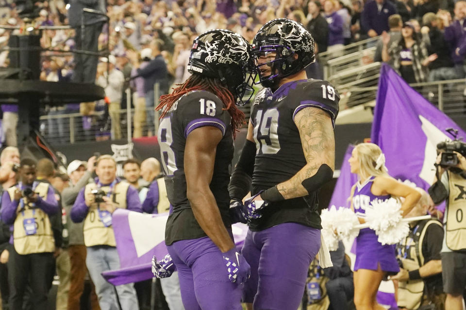 TCU tight end Jared Wiley (19) and wide receiver Savion Williams (18) celebrate a two-point conversion by Wiley in the second half of the Big 12 Conference championship NCAA college football game, Saturday, Dec. 3, 2022, in Arlington, Texas. (AP Photo/LM Otero)