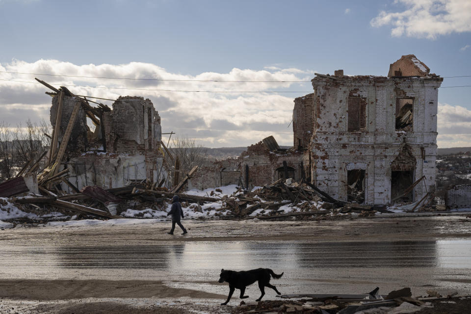 FILE - A woman walks by a building destroyed by a Russian strike in Kupiansk, Ukraine, Monday, Feb. 20, 2023. Grueling artillery battles have stepped up in recent weeks in the vicinity of Kupiansk, a strategic town on the eastern edge of Kharkiv province by the banks of the Oskil River as Russian attacks intensifying in a push to capture the entire industrial heartland known as the Donbas, which includes the Donetsk and the Luhansk provinces. (AP Photo/Vadim Ghirda, File)