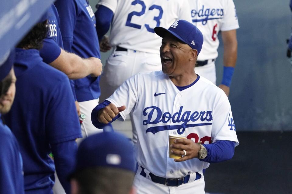 Dodgers manager Dave Roberts laughs as he walks through the dugout prior to a game on July 3, 2023, in Los Angeles.