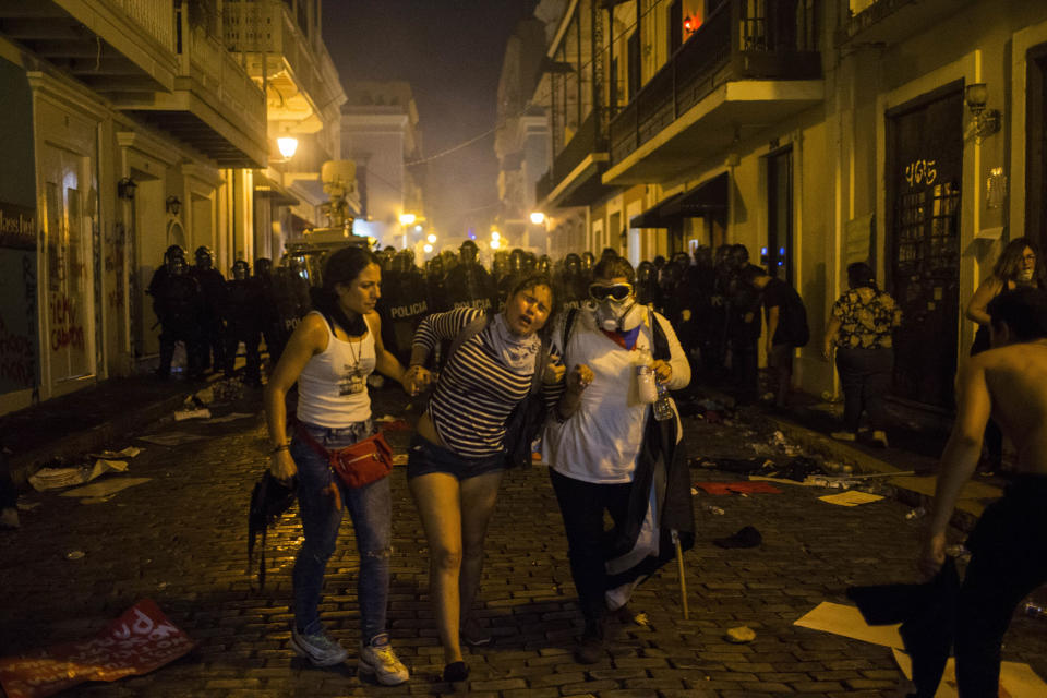 Demonstrators affected by tear gas thrown by the police run during clashes near the executive mansion demanding the resignation of Gov. Ricardo Rossello, in San Juan, Puerto Rico, Wednesday, July 17, 2019. (Photo: Dennis M. Rivera Pichardo/AP)