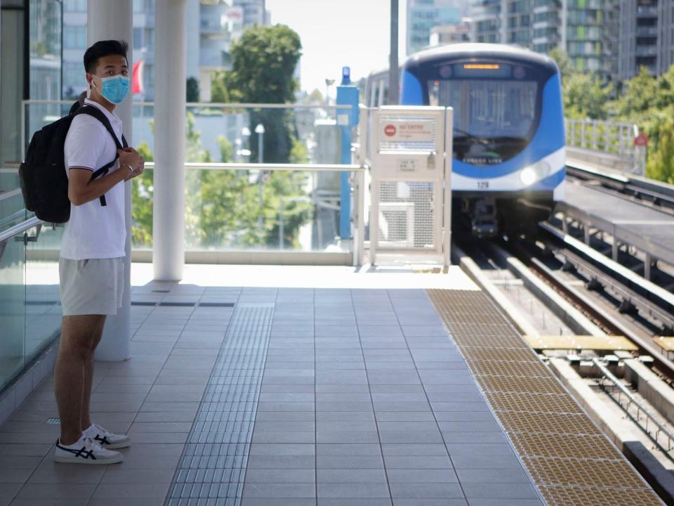 A passenger wearing a face mask waits to ride a SkyTrain in Vancouver, British Columbia, Canada, on July 18, 2020.