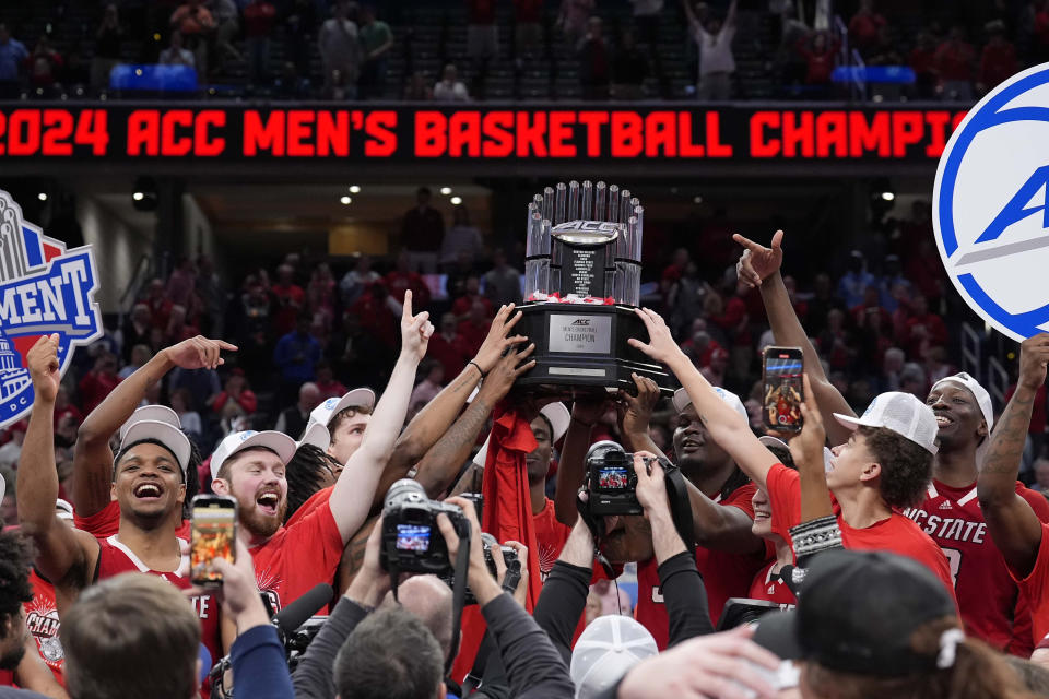 North Carolina State hoists the trophy after winning an NCAA college basketball game against North Carolina to win the championship of the Atlantic Coast Conference tournament, Saturday, March 16, 2024, in Washington. North Carolina State won 84-76.(AP Photo/Alex Brandon)