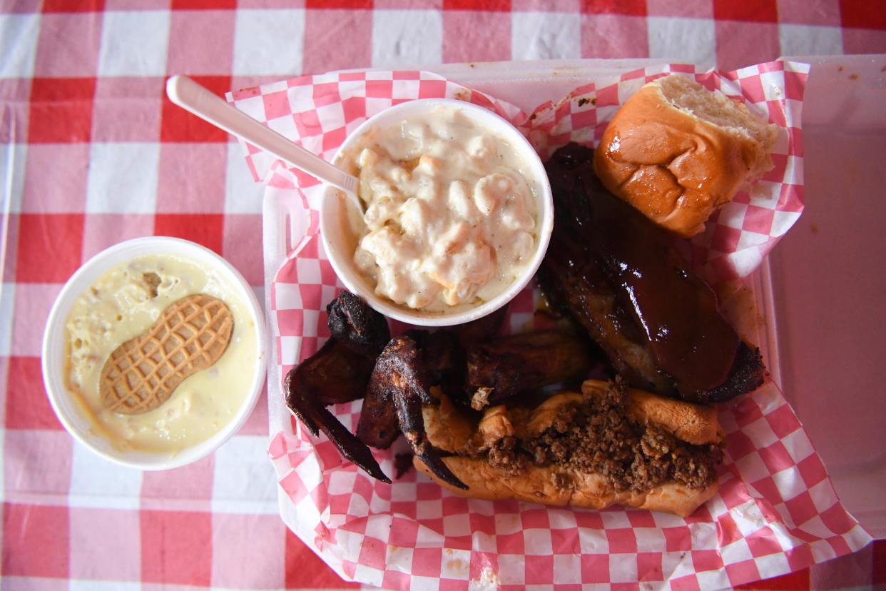 A dinner plate including banana pudding, macaroni and cheese, a chili dog, smoked and fried wings, and a rib, at Billie Rae’s BBQ on Magnolia Avenue, Saturday, May 4, 2024.