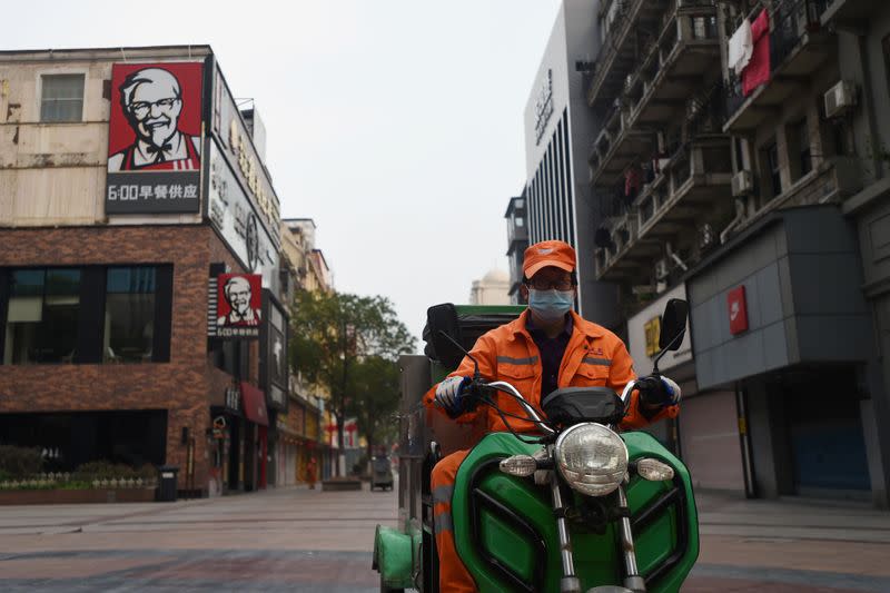 Sanitation worker rides his vehicle near a KFC restaurant on a pedestrian street in Wuhan, the epicentre of the novel coronavirus outbreak