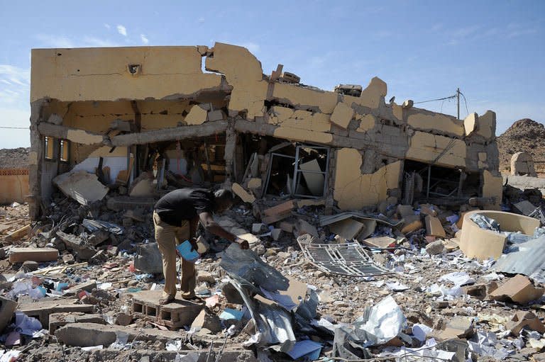 A Malian man searches on February 5, 2013 in the ruins of a building destroyed by French air strikes in Douentza