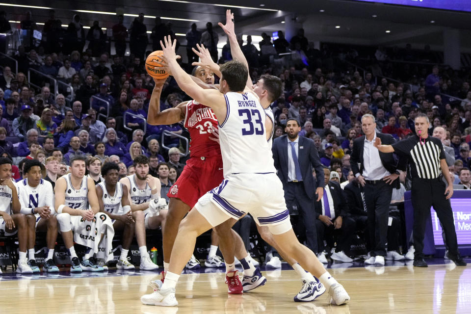 Ohio State forward Zed Key, left, looks to pass the ball as Northwestern forward Luke Hunger (33) and guard Brooks Barnhizer, right, guard during the first half of an NCAA college basketball game in Evanston, Ill., Saturday, Jan. 27, 2024. (AP Photo/Nam Y. Huh)