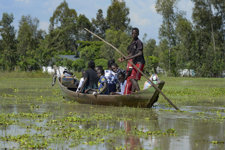 A family uses a canoe after fleeing floodwaters that wreaked havoc in Ombaka Village, Kisumu, Kenya, Wednesday, April 17, 2024. East Africa is experiencing heavy rains, with reported flooding in Tanzania that has killed 58 people and in neighbouring Kenya killing at least 13 people so far. (AP Photo/Brian Ongoro)