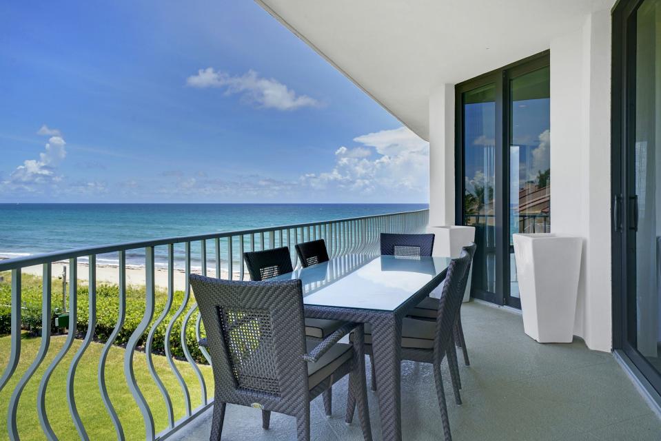 A dining table on the north balcony offers a view of the ocean.