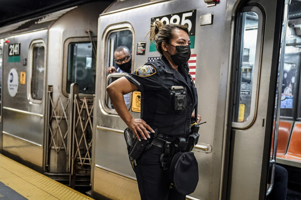 A New York City Police Department officer and a subway conductor look down the subway platform at the Grand Central Terminal subway station. - Credit: Frank Franklin II/AP