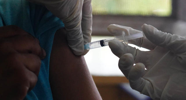 A vaccination is injected into a patient&#39;s arm.
