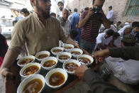 <p>A man distributes meal to people on the first day of Eid al-Adha, or Feast of Sacrifice, in Karachi, Pakistan, Saturday, Sept. 2, 2017. (Photo: Fareed Khan/AP) </p>