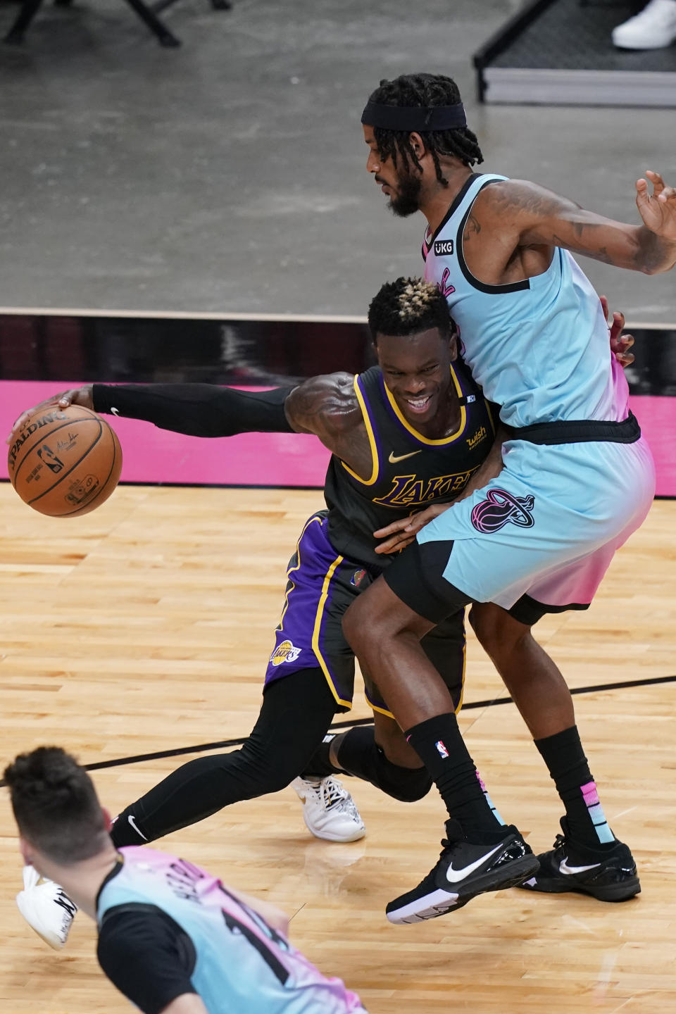 Los Angeles Lakers guard Dennis Schroder (17) tries to dribble around Miami Heat forward Trevor Ariza (8), during the first half of an NBA basketball game, Thursday, April 8, 2021, in Miami. (AP Photo/Marta Lavandier)