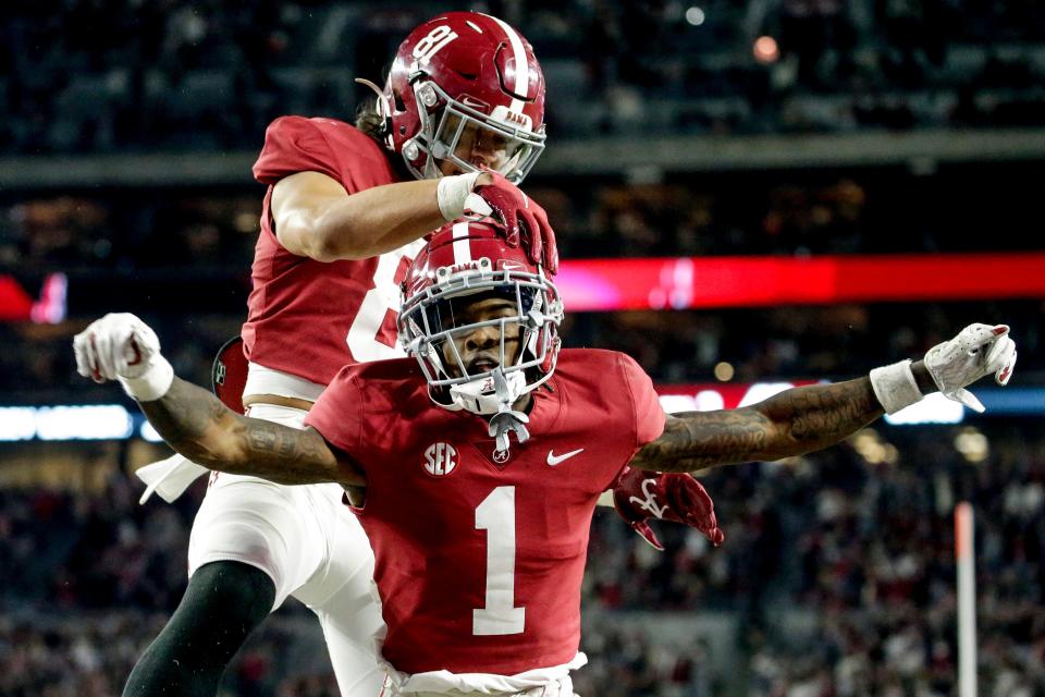 Alabama wide receiver Jameson Williams (1) celebrates with teammate Cameron Latu after scoring a touchdown against Arkansas.