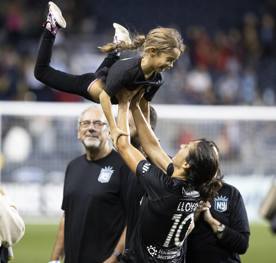 NJ/NY Gotham FC's Carli Lloyd lifts up a young relative as she greets family after the team's NWSL soccer match against the Washington Spirit on Wednesday, Oct. 6, 2021, in Chester, Pa. (Charles Fox/The Philadelphia Inquirer via AP)