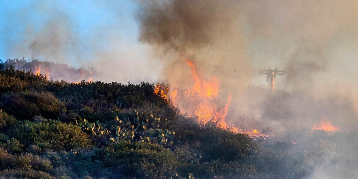 A brush fire burns in the hills.