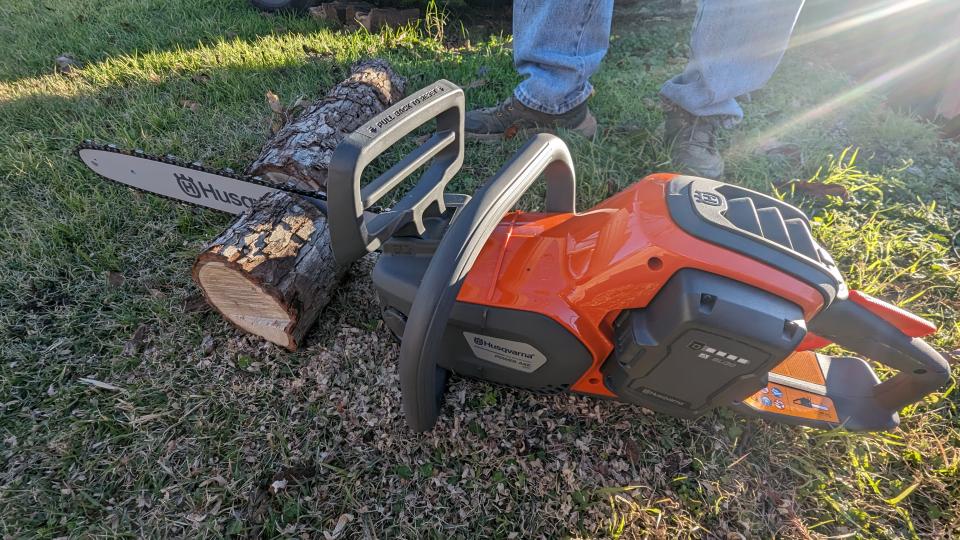 The Husqvarna Power Axe 350i Cordless Electric Chainsaw being tested on a log in a yard