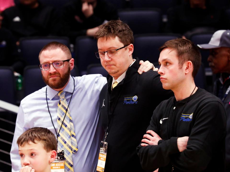 Assistant coach Jared Cox, left, consoles head coach Dave Brown following Maysville's 68-54 loss to Kettering Alter during the Division II state finals on Sunday at University of Dayton Arena.