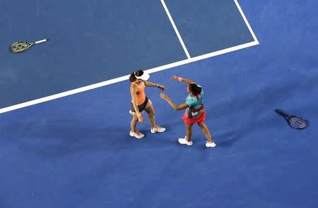 Switzerland's Martina Hingis (L) and India's Sania Mirza celebrate after winning their doubles final match at the Australian Open tennis tournament at Melbourne Park, Australia, January 29, 2016. REUTERS/Jason Reed