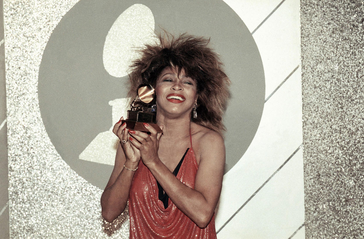 Tina Turner holds up a Grammy Award at the 27th Annual Grammy Awards in 1985.
