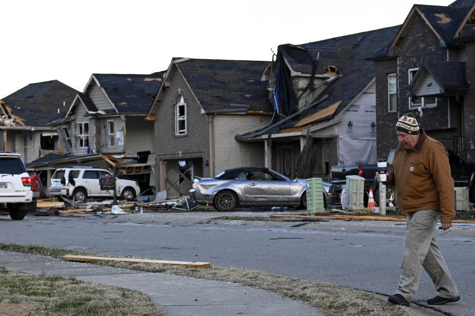 Jim Mitun walks amid homes destroyed in the West Creek Farms neighborhood on Sunday, Dec. 10, 2023, Clarksville, Tenn. Central Tennessee residents and emergency workers are continuing the cleanup from severe weekend storms. (AP Photo/Mark Zaleski)