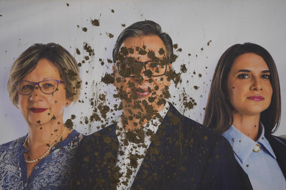 A vandalized pre-election billboard showing Serbian President Aleksandar Vucic, center, with associates in Belgrade, Serbia, Thursday, May 30, 2024, ahead of the municipal vote set for June 2. Voters in Serbia go to the polls this weekend in a municipal election for dozens of cities and towns, including a rerun vote in the capital Belgrade where ruling populists were accused of a fraud at a previous vote in December. The right-wing Serbian Progressive Party of President Aleksandar Vucic is seen as a favorite ahead of the Sunday balloting which could further secure the strongman's already vast hold on power. (AP Photo/Darko Vojinovic)