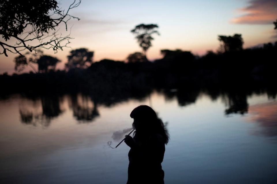 Mapulu, a Kamayura woman, smokes herbs during a fishing ritual (Reuters)