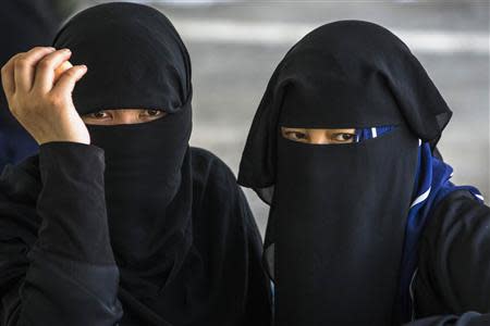 Suspected Uighurs from China's troubled far-western region of Xinjiang, look on inside a temporary shelter after they were detained at the immigration regional headquarters near the Thailand-Malaysia border in Hat Yai, Songkla March 14, 2014. REUTERS/Athit Perawongmetha