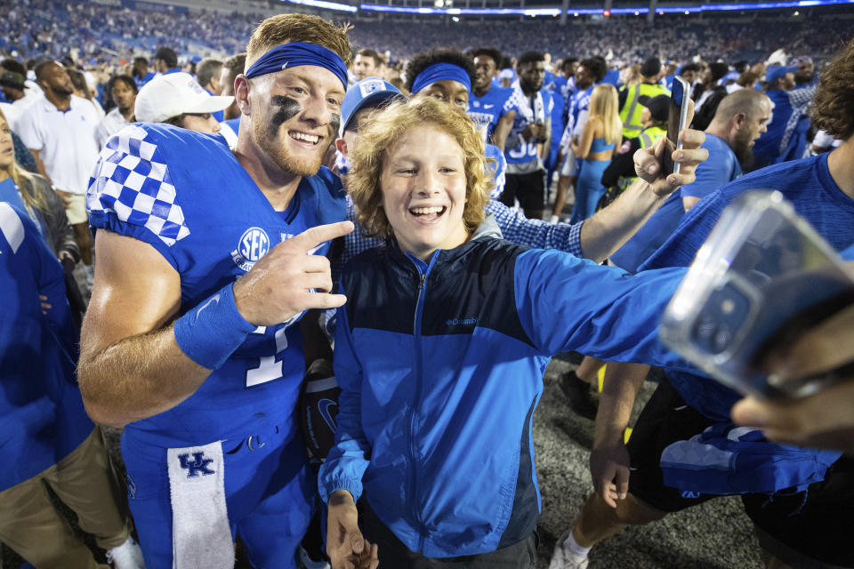 Kentucky quarterback Will Levis, left, has his photo taken with a fan on the field after winning an NCAA college football game against Florida in Lexington, Ky., Saturday, Oct. 2, 2021. (AP Photo/Michael Clubb)