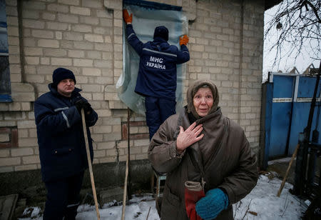 A local resident is seen as Emergencies Ministry members repair her home which was damaged during fighting between the Ukrainian army and pro-Russian separatists in the government-held industrial town of Avdiyivka, Ukraine, February 6, 2017. REUTERS/Gleb Garanich