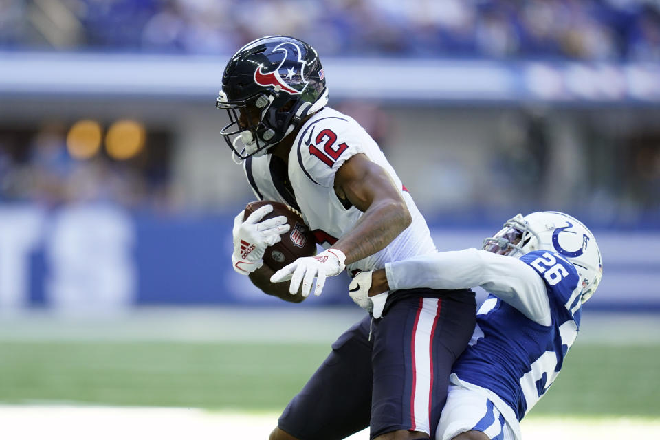 Houston Texans' Nico Collins (12) is tackled by Indianapolis Colts' Rock Ya-Sin (26) during the first half of an NFL football game, Sunday, Oct. 17, 2021, in Indianapolis. (AP Photo/Michael Conroy)