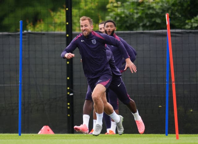 Harry Kane laughs as he runs around a cone during England training