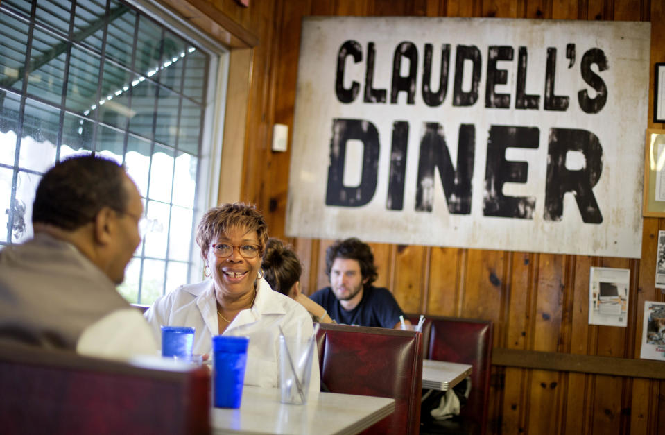 JoAnn Williams, of Atlanta, sits in the dining room of the Home grown restaurant as a sign left behind from filming the movie "Trouble With the Curve," starring Clint Eastwood, hangs on the wall, Tuesday, Oct. 22, 2013, in Atlanta. A couple miles east of downtown Atlanta on the fringe of a historic blue-collar neighborhood, Home grown serves up satisfying Southern fare in an eclectic atmosphere. (AP Photo/David Goldman)