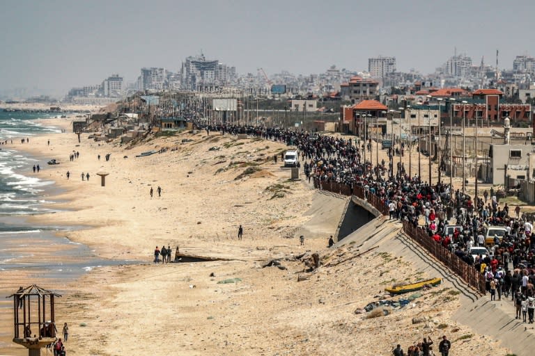 Des milliers de Palestiniens déplacés dans le sud de la bande de Gaza marchent, le 14 avril 2024, le long de la mer pour tenter de regagner le nord du territoire (-)