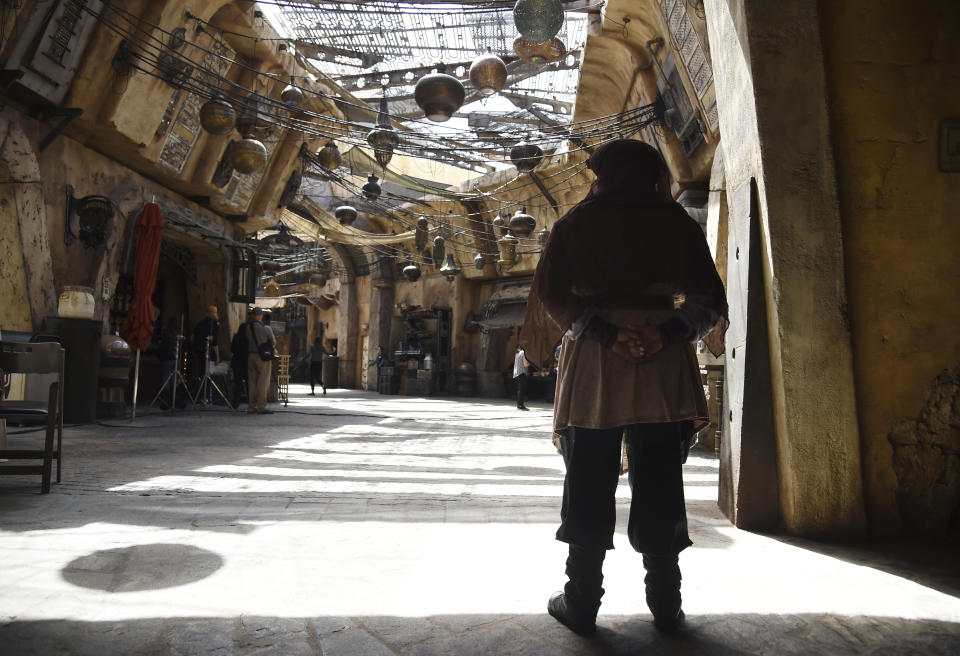 A character looks out to the marketplace in the Black Spire Outpost during the Star Wars: Galaxy's Edge Media Preview at Disneyland Park, Wednesday, May 29, 2019, in Anaheim, Calif. (Photo by Chris Pizzello/Invision/AP)