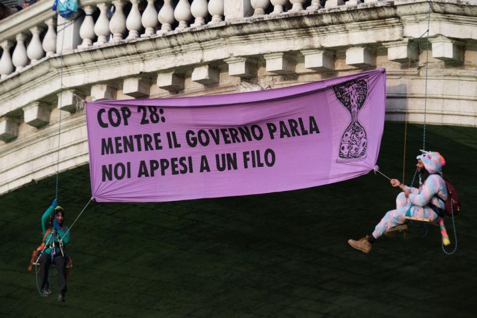 Extinction Rebellion activists dangle from the Rialto Bridge alongside their banner (Reuters)