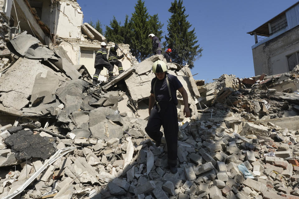 Firefighters dig through the rubble of the school building destroyed during a missile strike in Kharkiv, Ukraine, Monday, July 4, 2022. (AP Photo/Andrii Marienko)