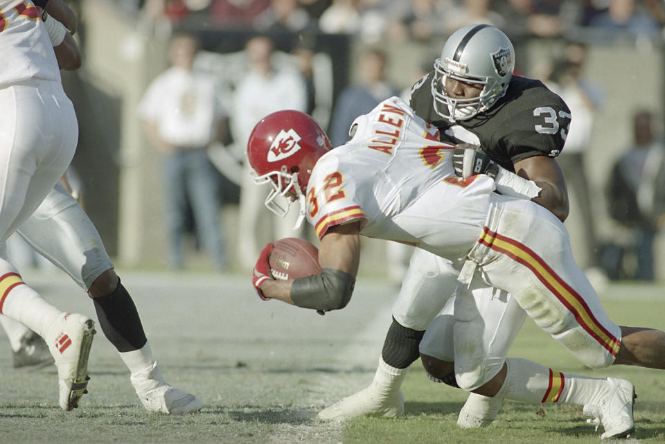 FILE - Kansas City Chiefs' running back Marcus Allen crosses the goal line for a third quarter touchdown as Los Angeles Raiders' Eddie Anderson tries to stop him in Los Angeles, in this Nov. 14, 1993, file photo. The Chiefs won, 31-20. A league MVP and Super Bowl winner with the Raiders, Allen left in 1993 when team owner Al Davis insisted he be a backup in a nasty feud with the player. Allen landed in Kansas City (Joe Montana already had arrived from the 49ers) and despite a mediocre performance he helped the Chiefs to a Game 4 home victory. (AP Photo/Eric Draper, File)