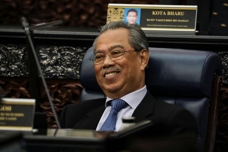 Malaysia's Prime Minister Muhyiddin Yassin smiles during a session of the lower house of parliament, in Kuala Lumpur