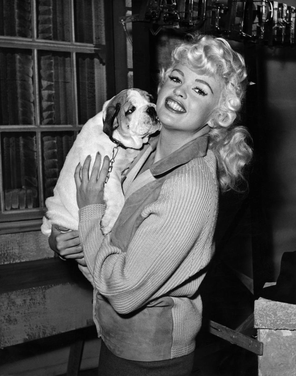 <p>Jayne Mansfield smiles with her five-month-old bulldog, Challenge, on the set of her movie <em>The Challenge</em>. The American bombshell, who was in England for a few months shooting the film, was given the puppy as a gift by an admirer. </p>
