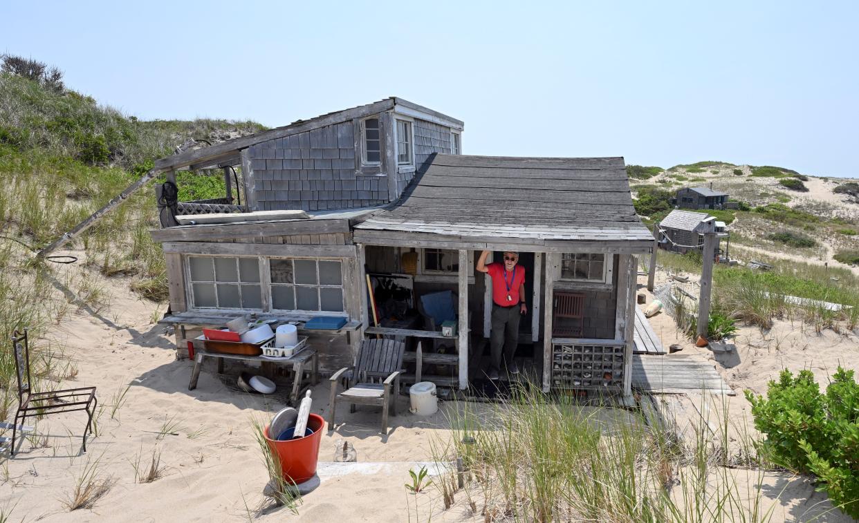 Peter Clemons standing in the doorway of his family's dune shack, which they call The Grail, in June 2023 in Provincetown.